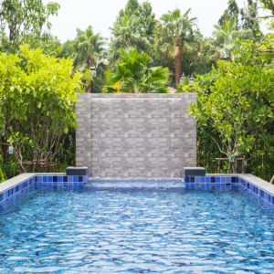 Swimming pool in backyard with fountain curtain Blue water and b